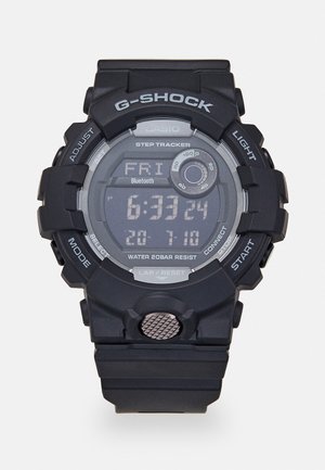 Schwarze G-SHOCK-Uhr mit digitaler Anzeige, Schrittzähler, Bluetooth, wasserdicht bis 20 bar, akzentuierte Tasten und strukturiertes Gehäuse.