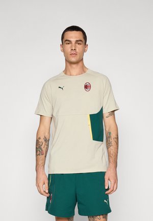 Lys beige sports t-shirt med en grøn accentlomme, gul lynlåsdetalje og broderet logo. Korte ærmer og rund halsudskæring.