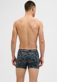 Boxershorts mit einem schwarzen Elastikbund, auf dem "JACK & JONES" steht. Der Stoff ist dunkel und hat ein blätterähnliches Muster in grünen und orangenen Farbtönen.