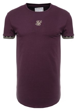 Lilla kortærmet t-shirt i bomuld med rund hals; har et gyldent broderet logo på brystet og mønstrede sorte og gyldne manchetter.