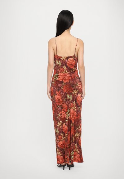 Floral maxi dress with red and green flower pattern. Features thin adjustable straps and a flowing silhouette. Made of lightweight fabric.