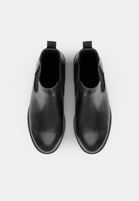 Svarta läderankelstövlar med elastiska sidopaneler, rundad tå och dragloop baktill. Slät textur med en minimalistisk design.