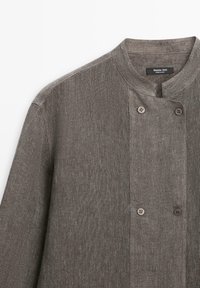 Hnědá texturovaná látková bunda se stojáčkem a čtyřmi viditelnými knoflíky na předním dílu, označená Massimo Dutti.