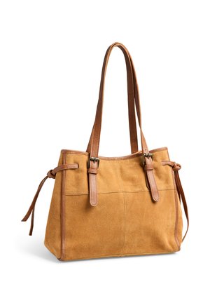 Sac à main en daim marron clair avec des lanières en cuir marron, des détails à boucle et des liens sur les côtés, présenté sur un fond blanc.