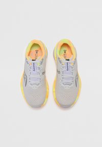 Baskets de course gris clair avec une tige en mesh, accents jaune fluo et une semelle rembourrée. Présente un motif texturé et un branding contrastant.