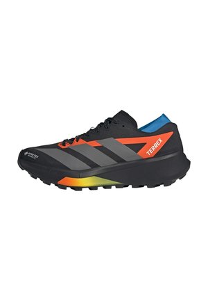 Zapatilla de trail running Adidas Terrex negra con detalles en naranja y gris, forro interior azul y suela resistente con etiqueta impermeable Gore-Tex.