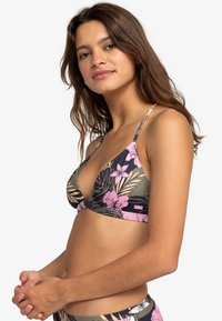 Top de bikini floral con un diseño triangular en verde oscuro con patrones florales en rosa y beige. Tirantes ajustables y textura suave.