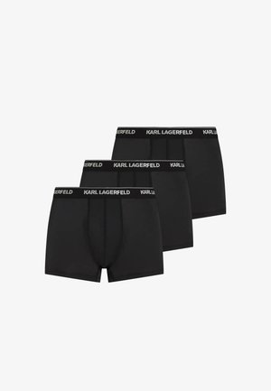 Trois boxers noirs pour hommes avec des ceintures élastiques "KARL LAGERFELD" superposées sur un fond blanc.