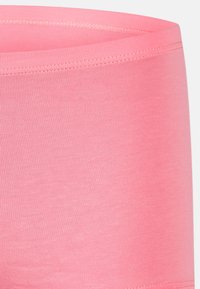 Elastisk midja, figursydd design i starkt rosa. Mjuk, slät textur med ett ribbat mönster på tyget. Lämplig för aktiv träning.