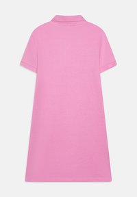 Vestido polo de manga corta en rosa brillante, con un cuello clásico, textura de tela suave y un ajuste holgado y relajado.