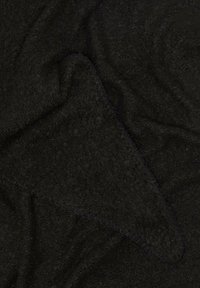 Schwarzer Fleece-Stoff mit einer weichen, strukturierten Oberfläche, die reichhaltige, tiefe Fasern und subtile Muster zeigt, gefaltet, um seine Dicke zu enthüllen.