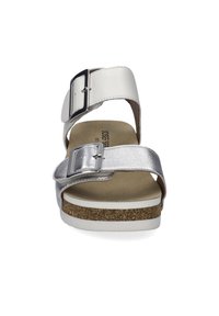 Witte sandalen met twee verstelbare banden, waarvan één metallic zilver. Kurken voetbed, witte rubberen zool en een gladde afwerking. Functionele gespaccenten.