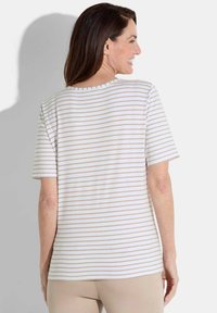 Streepjesshirt met korte mouwen in wit en lichtbeige, voorzien van een ronde hals en een relaxte pasvorm, met een zachte, katoenachtige textuur.