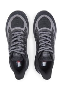 Μαύρα και γκρι αθλητικά παπούτσια με διχτυωτό επάνω μέρος, στρογγυλεμένη μύτη, υφή σε σχήματα, αντανακλαστικά κορδόνια και λογότυπο στη γλώσσα.