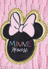Il tessuto lavorato a maglia rosa presenta un logo di Minnie Mouse in nero, con un fiocco rosa, contornato in oro, che mostra "MINNIE Mouse" in un testo colorato.