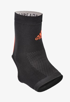 Black athletic sock with textured fabric, mid-calf height, featuring an orange logo and accents. Smooth ankle opening for comfort.