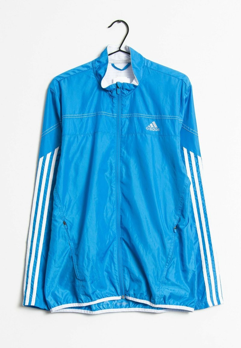 Blå vindtät jacka i lätt material, med vita detaljer, dragkedja fram och tre vita ränder på varje ärm.