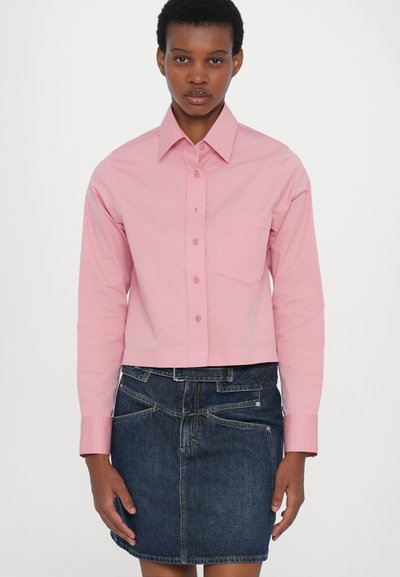 Kuttet rosa skjorte med klassisk krage, knapplukking foran, lange ermer og én brystlomme, kombinert med en mørk denim miniskjørt.