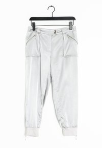 Ljusgrå joggerbyxor i ett mjukt material, med dragkedjefickor, knappstängning och elastiska muddar med dragkedjor.