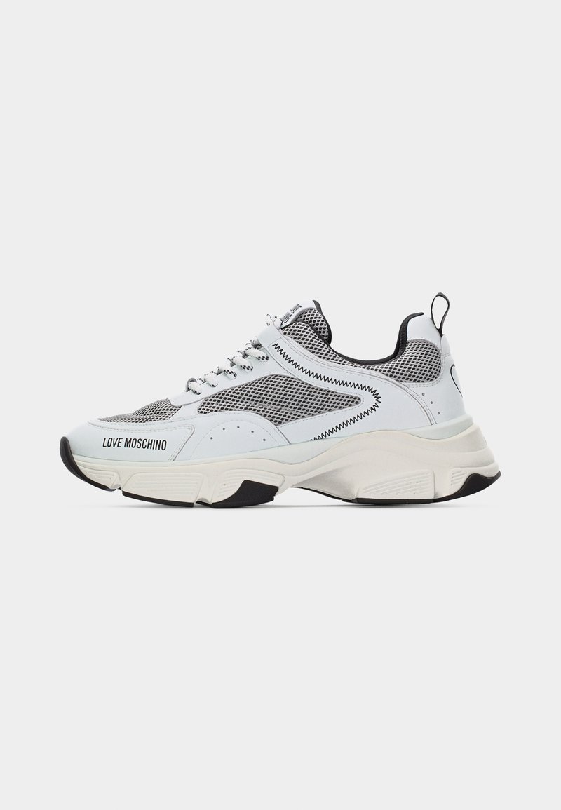Λευκό και γκρι δίχτυ Love Moschino αθλητικό παπούτσι με χοντρή σόλα, κλείσιμο με κορδόνια, μαύρες λεπτομέρειες και θηλιά στην πτέρνα.