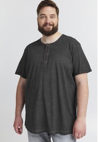 Tricou scurt, gri închis, cu mânecă scurtă și decolteu rotund, având trei butoane maro decorative și o croială relaxată. Material moale și ușor.