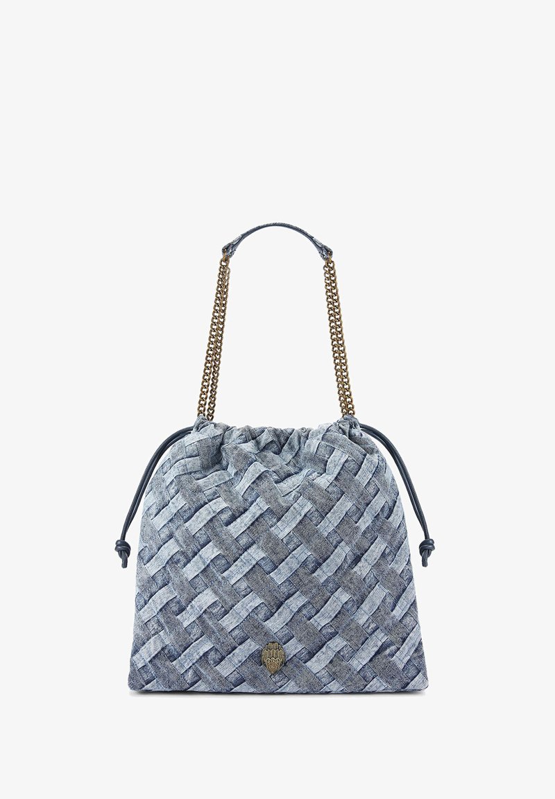 Sac en denim tissé de teintes de bleu avec une fermeture à cordon, des anses doubles en chaîne, et un emblème rond représentant un design de main.