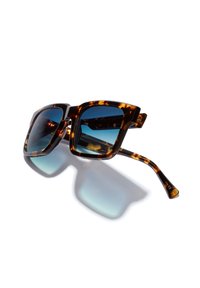 Schildpatt-Sonnenbrille mit quadratischen Rahmen, verlaufenden blauen Gläsern und schlanken Bügeln, die eine glatte, glänzende Textur aufweisen.