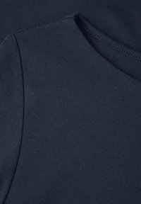 Navyblauer Baumwollstoff mit glatter Textur, rundem Halsausschnitt und nahtlosem Schuldesign, das eine minimalistische Ästhetik betont.