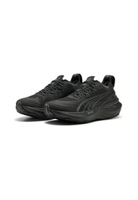 Black athletic shoes with a textured mesh upper, curved sole, and prominent lacing system. Features Puma logo on the side and distinctive tread pattern.