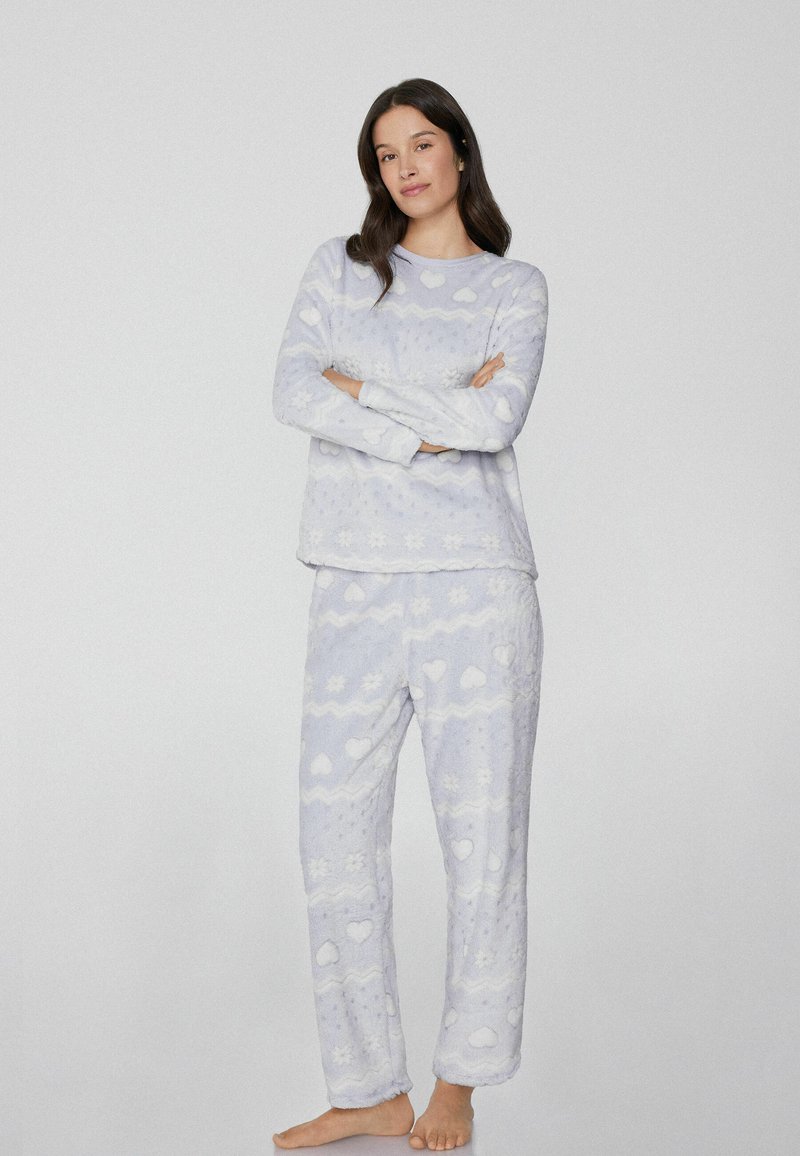 Himmelblaues Pyjama-Set mit einem Langarmoberteil mit Herzmustern und passenden Hosen mit Zickzackdesigns, hergestellt aus weichem, kuscheligem Material.