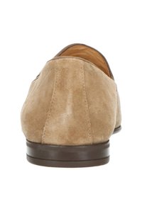 Beige suède instappers met een gladde, ronde vorm en een bruine rubberen zool. Voorzien van stiksels aan de achterkant voor extra textuur.