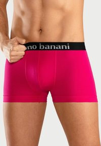 Pink cotton boxer shorts with a black waistband featuring white text. The fabric appears smooth with a snug fit and minimal seams.