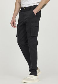 Pantalons cargo noirs en tissu durable, dotés de plusieurs poches latérales, d'une coupe décontractée et d'une fermeture à bouton à la taille.