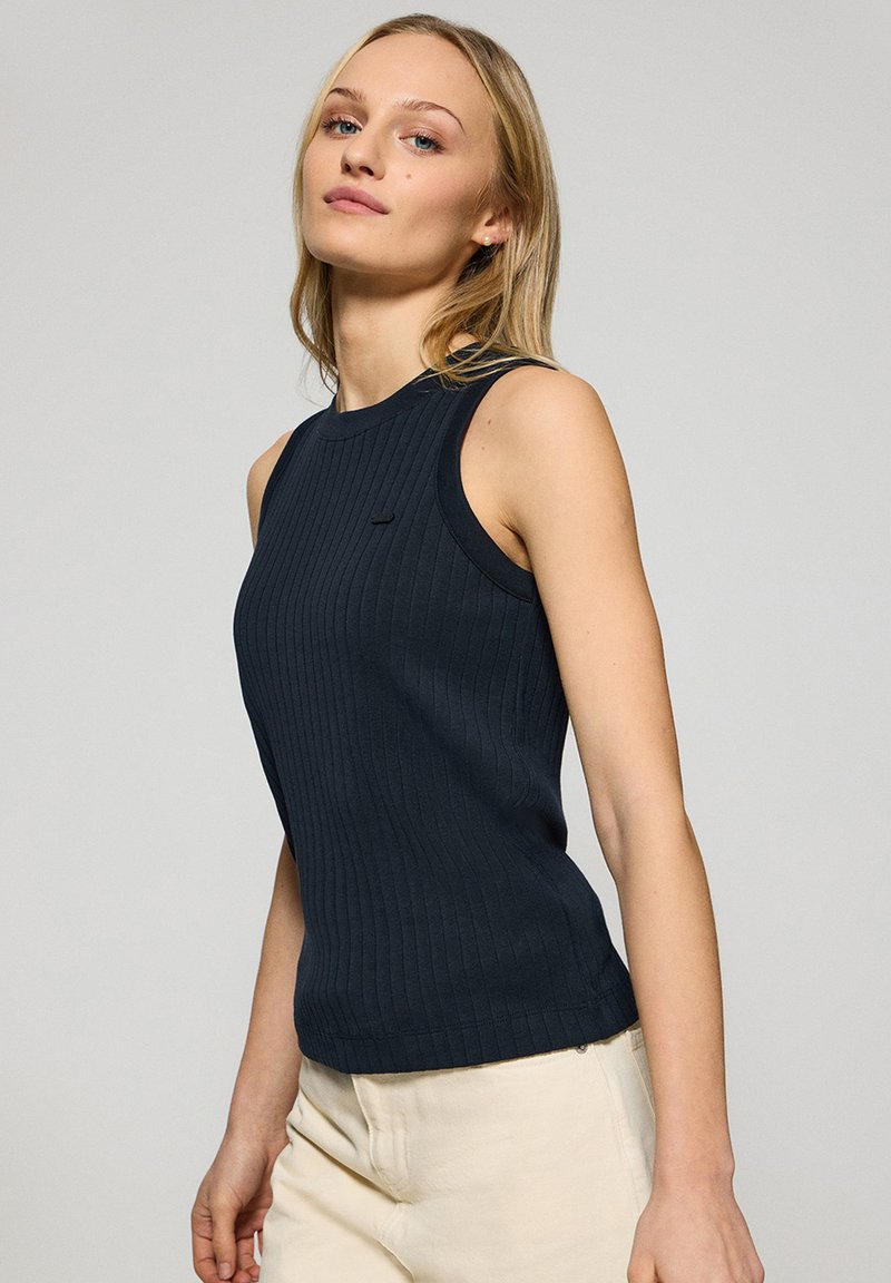 Marinblå ribbad ärmlös topp med rund halsringning, med en liten logotypdetalj på bröstet och en figurnära siluett.