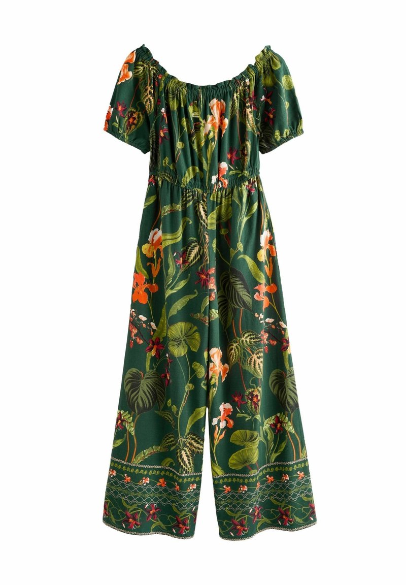 Combinaison verte épaules dénudées avec manches bouffantes et jambes larges ornée d'un imprimé tropical coloré floral et feuillage.