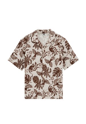 Chemise crème à manches courtes avec imprimé tropical marron mettant en scène des singes, des oiseaux, des feuilles et des fleurs, posée à plat sur un fond blanc.