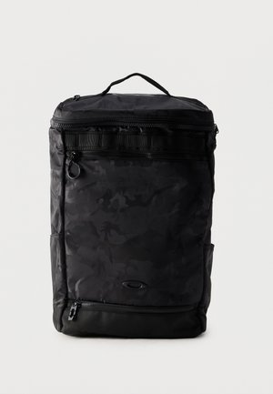 Rucsac negru dreptunghiular cu model subtil camuflaj, mâner superior, mai multe compartimente cu fermoar și logo oval mic în față.
