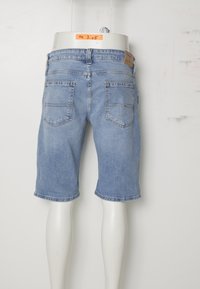 Shorts de mezclilla azul claro con un corte relajado, que cuentan con dos bolsillos traseros y detalles de costura. Terminados con un dobladillo vuelto y una etiqueta de cuero.