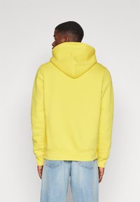 Tommy Hilfiger ARCHED VARSITY HOODY - Sportinis megztinis - eureka yellow