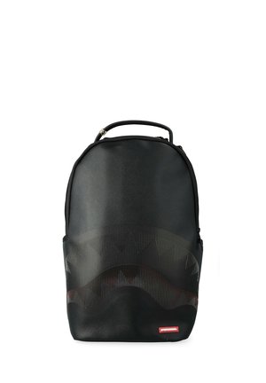 Mochila negra con superficie texturizada, asa superior y patrón sutil de rayas curvas en la parte frontal sobre fondo blanco.