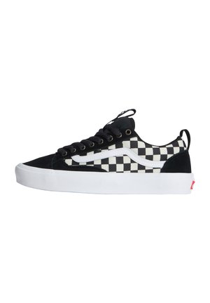 Baskets basses à motif damier noir et blanc avec bande latérale blanche, lacets noirs et semelle blanche épaisse.