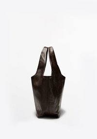 Sac fourre-tout en cuir marron foncé avec de larges poignées, debout sur un fond blanc uni.