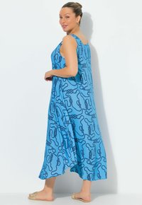 Blå ärmlös maxiklänning med en flödande siluett, med ett mörkblått repmönster och en mjuk tygstruktur.