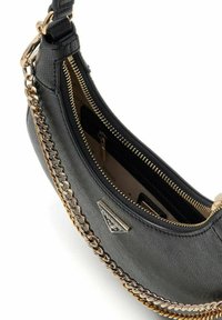 Sac à main en cuir noir avec accents en chaîne dorée, fermeture éclair et plaque logo. L'intérieur comporte des doublures contrastantes et des poches.