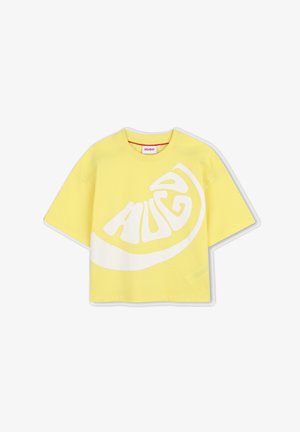 T-shirt court à manches courtes jaune avec une coupe large et un motif abstrait blanc formant le mot "HUGO" sur le devant.
