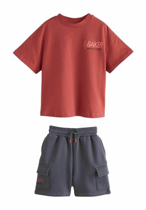 T-shirt manches courtes couleur rouille avec inscription « Baker », associé à un short cargo gris foncé à taille élastique avec cordon et poches latérales.
