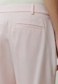 Helle rosa Hose aus glattem Stoff mit geradem Schnitt, zwei Gesäßtaschen und einem sauberen Bund ohne sichtbare Verschlüsse.