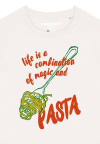 Crèmekleurige t-shirt met rode en groene tekst: "het leven is een combinatie van magie en PASTA" met een afbeelding van spaghetti op een vork.