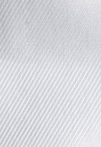 Tessuto strutturato di colore azzurro chiaro con motivo a spina di pesce, caratterizzato da sottili linee diagonali per un aspetto sottile e definito.