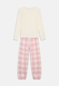 Εκρού μπλούζα με μακριά μανίκια σε συνδυασμό με ροζ και λευκό ριγέ παντελόνι πυτζάμας με ελαστικές μανσέτες και μέση. Μαλακό βαμβακερό ύφασμα.